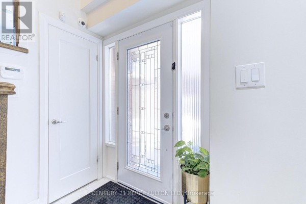 Interior view of the front entryway with a glass-paneled door and white walls. - 109 Woodcroft Lane, Vaughan