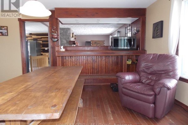 Basement with wood paneling, barn door, barbell, and dumbbells - 1091 County Rd 15 Road Alfred And Plantagenet