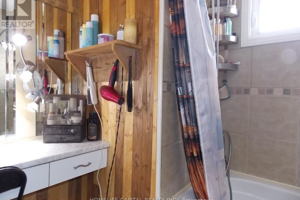 Renovated bathroom with wood wall paneling, bathtub, and vanity - 1091 County Rd 15 Road Alfred And Plantagenet