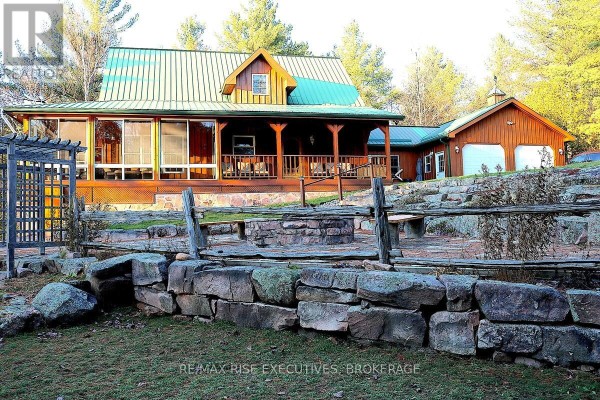 Exterior view of house with screened porch and stone patio with fire pit. - 1093b Two Loon Lane, Frontenac