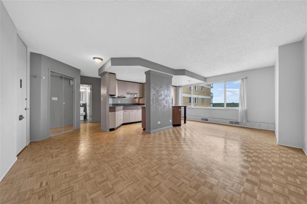 Living and kitchen area with parquet flooring and large window. - 10h 300 Roslyn Road, Winnipeg
