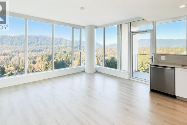 Living room with panoramic windows showcasing extensive green space and mountain vistas. - 10xx 567 Clarke Road, Coquitlam
