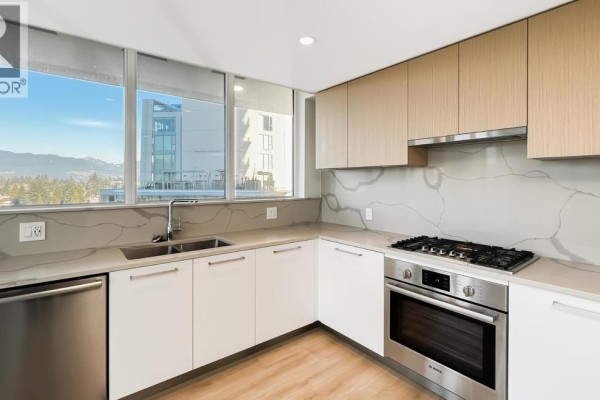 Close-up of the kitchen featuring dual-tone cabinetry, gas stovetop, and integrated sink. - 10xx 567 Clarke Road, Coquitlam