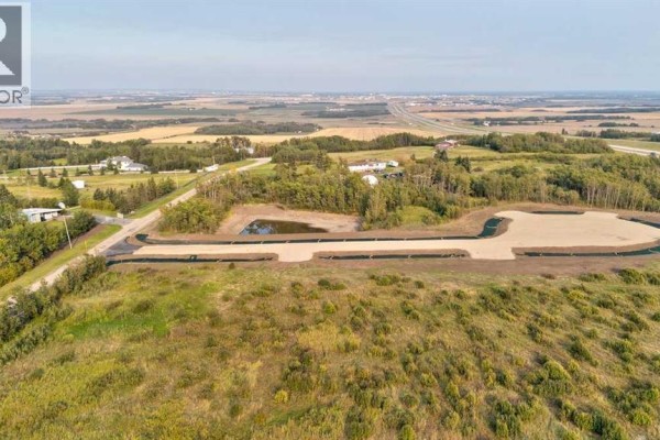 View of prepared land with a small pond and road infrastructure in a rural setting. - 11, 701413 Range Road 72, Rural Grande Prairie No  1, County Of