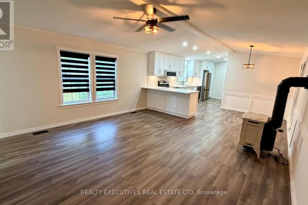 View from the living room towards the kitchen, showing an island and white cabinets. - 11 - 10146 County 43 Road, North Dundas