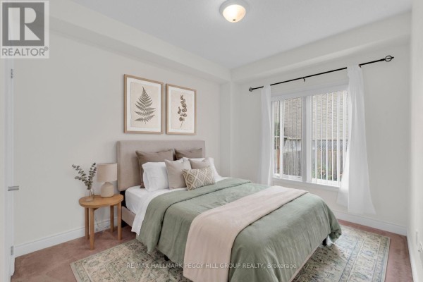 Bedroom with a queen-size bed, beige upholstered headboard, and a window with white curtains. - 11 - 125 Huronia Road, Barrie