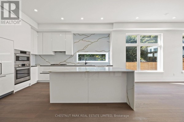 Modern kitchen with white high-gloss cabinets, stainless steel appliances, and quartz countertops. - 11 - 20 Lou Parsons Way, Mississauga