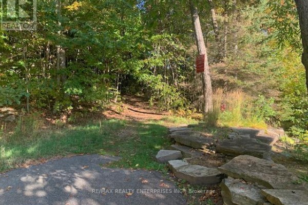 Pathway leading into the woods with stone borders and trees on either side. - 11 - 4031 Grandview Forest Hill Drive, Huntsville