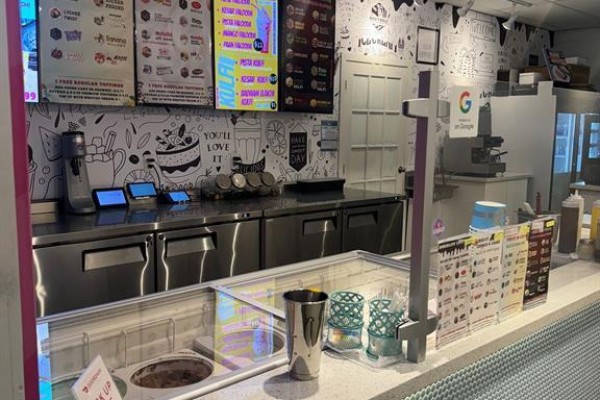 Ice cream shop counter with menu boards, touchscreen ordering stations, and refrigerated display cases. - 11 - 511 Ray Lawson Boulevard E, Brampton