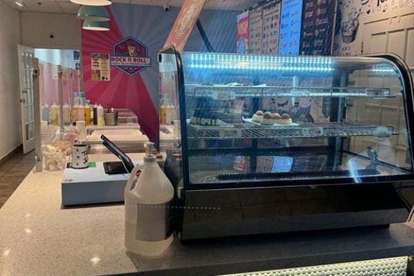 Display case filled with desserts next to a hand sanitizer dispenser and cash register. - 11 - 511 Ray Lawson Boulevard E, Brampton