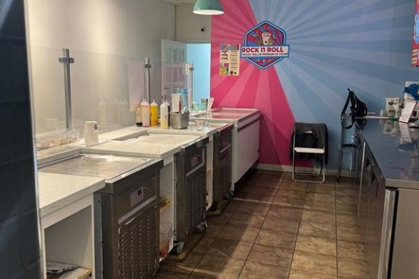 Commercial ice cream preparation area with stainless steel equipment and colorful wall graphics. - 11 - 511 Ray Lawson Boulevard E, Brampton
