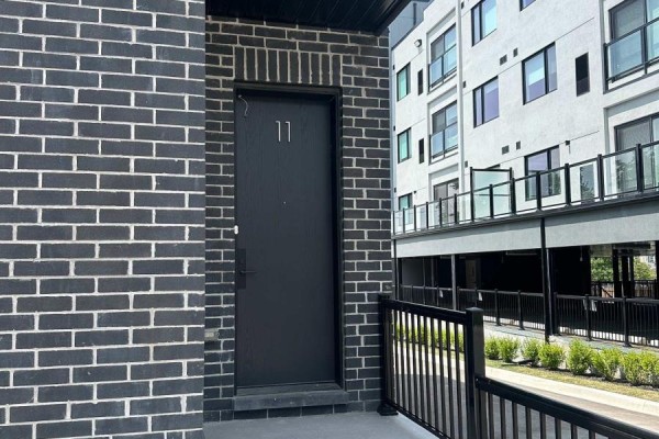 Exterior entrance door with number 11, surrounded by dark brick. - 11 - 59 Charles Street, Newmarket