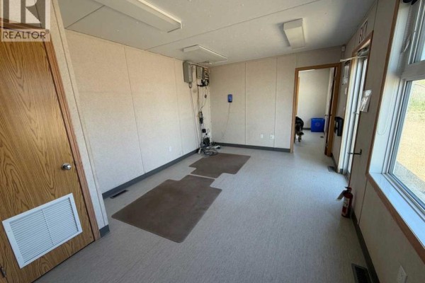 Interior of modular office with beige walls, two doors, and large window. - 11 & 13, 27123 Highway 597, Rural Lacombe County