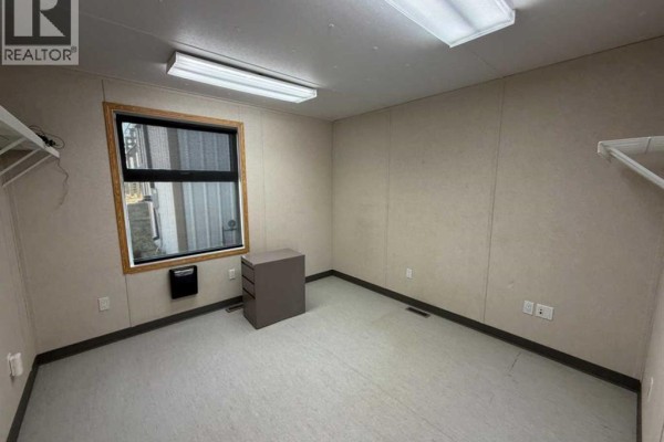 Small office room with beige walls, window, filing cabinet, and shelving. - 11 & 13, 27123 Highway 597, Rural Lacombe County