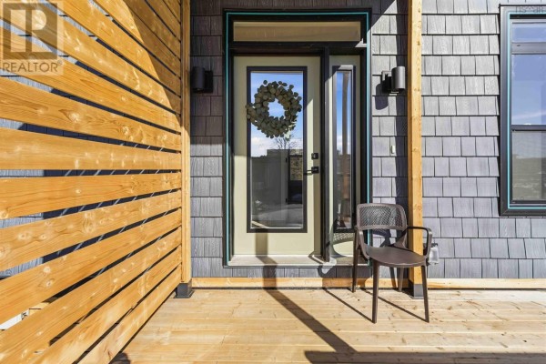 Close-up of the front door with a wreath and wooden slat wall. - 11 693 Masons Beach Road, First South