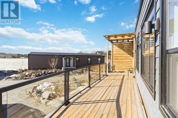Side view of the deck with glass railing and wooden slat feature. - 11 693 Masons Beach Road, First South