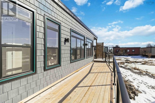 Another angle of the deck showing the exterior siding and nearby structures. - 11 693 Masons Beach Road, First South