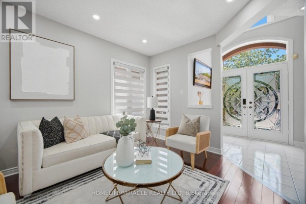 Living room area with entryway, mirrored closet doors, and view of hallway. - 11 Barleyfield Road, Brampton