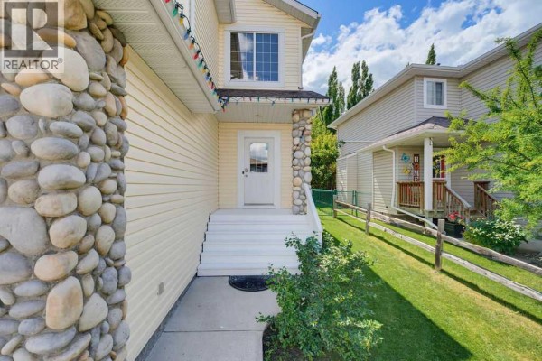 Close-up of the front entrance with stone pillars and white stairs. - 11 Bow Ridge Link, Cochrane