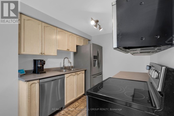 View of kitchen with stainless steel refrigerator, sink, dishwasher, and oven. - 11 Caribou Court, Barrie