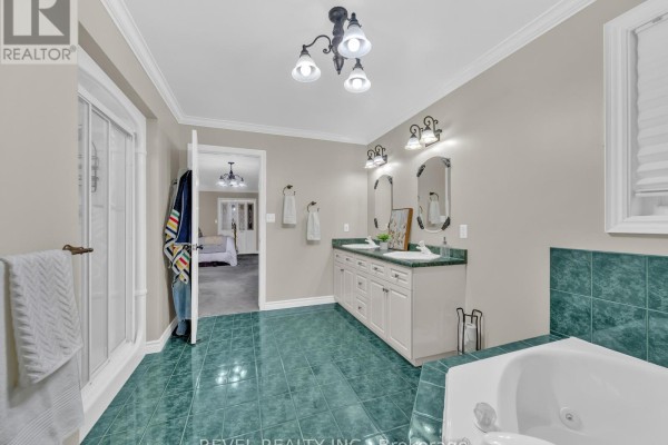 View of a master bathroom with a jacuzzi tub, double vanity with green countertops, and a view into the bedroom. - 11 Cramar Crescent, Chatham Kent