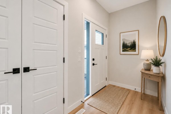 Spacious kitchen and living room with an island, modern cabinets, and a fireplace. - 11 Dalquist Bay, Leduc
