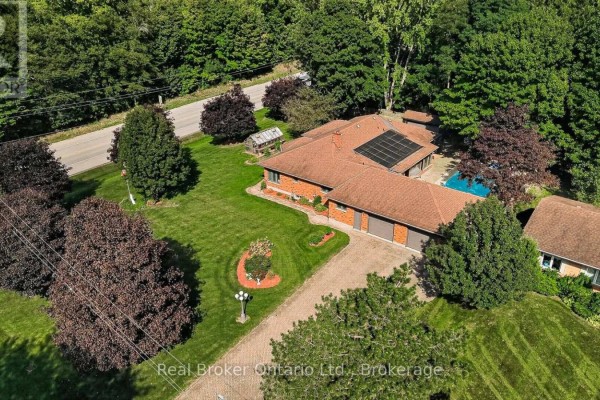 Aerial view of a ranch-style house with a circular driveway, pool, and attached garage. - 11 Elisabeth Street, East Zorra Tavistock