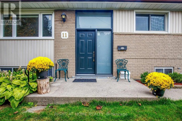 Close-up of the front entrance with a blue double door and decorative chairs. - 11 Fareham Crescent, Toronto