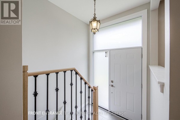 Interior view of the front entrance foyer with a white door and staircase. - 11 Fareham Crescent, Toronto