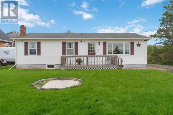 Exterior view of the house from the front yard, showing a large grassy area and a circular garden bed. - 11 Green Lane, Falmouth
