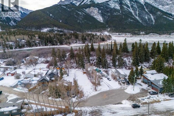 Aerial view of a winding road through a snowy residential area and mountains. - 11 Loder Mountain Drive, Exshaw