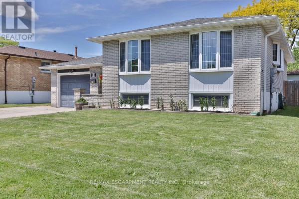 Front view of a detached townhouse with light grey brick and white trim. - 11 Lynwood Drive, Hamilton