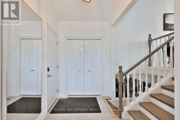 Kitchen with light grey cabinets, stainless steel appliances, granite countertops, and a small dining table. - 11 Lynwood Drive, Hamilton