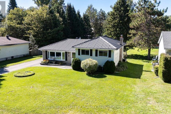 Aerial view of the front of a house with manicured lawn and mature trees. - 11 Pine Street, Bracebridge