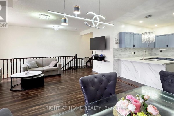 Open concept living space with dark wood floors and a modern kitchen. - 11 Pottle Lane, Ajax