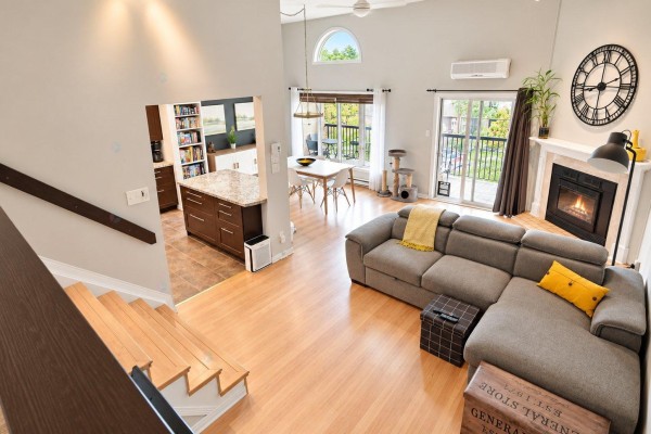 Living room with a large sectional sofa, fireplace, and view of a dining area. - 11 Rue De Toulouse, #e, Gatineau