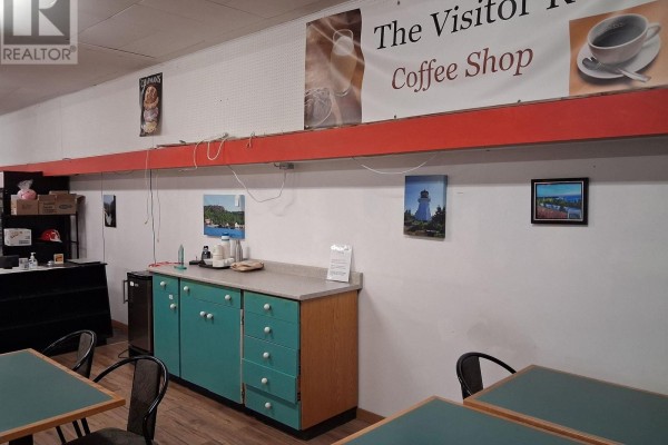 View of the coffee shop interior with a counter and artwork. - 11 Simcoe Plaza, Terrace Bay