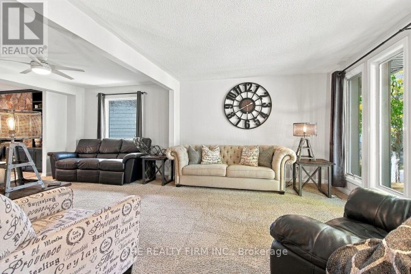 Living room with plush carpet, dark leather sofas, a tufted beige sofa, and large clock. - 11 Somerset Crescent, London South