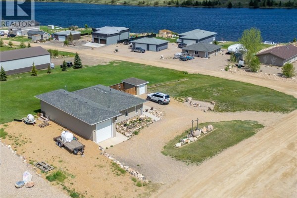 Aerial view of a residential property with a house, garage, and lake in the background. - 11 Sunrise Boulevard, Arm Lake