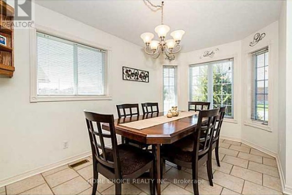 Dining room with a wood table and chairs, a chandelier, bay windows, and light tile floors. - 11 Violet Street, Barrie