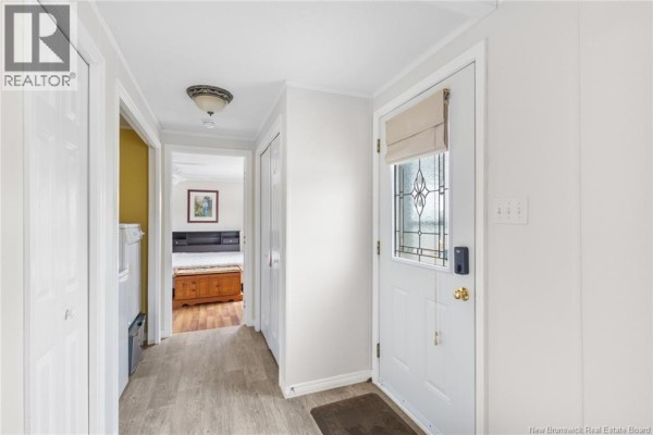 Interior view of a narrow hallway with white doors and a glass-paned front door. - 11 Wendy Crescent, Rusagonis