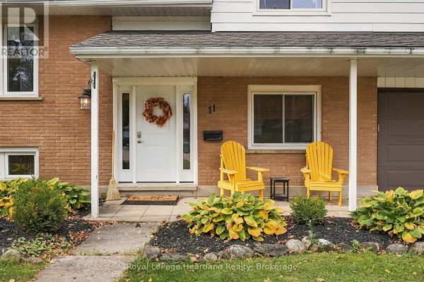 View of the front door and porch, featuring a wreath, house number 11, and two yellow chairs with a side table. - 11 William Street N, Minto