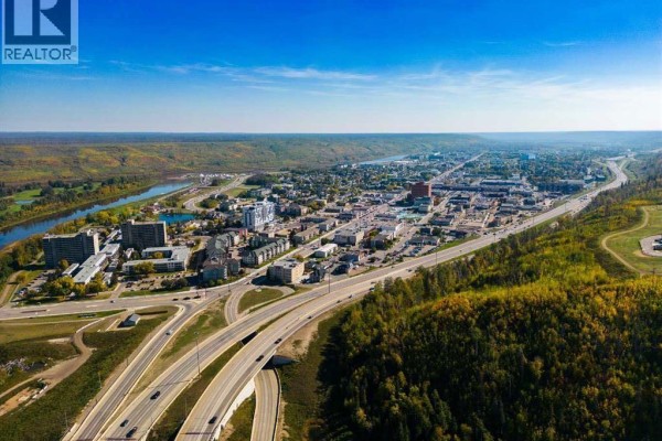 Aerial view of Fort McMurray city skyline with river and highway. - 110, 14921 Macdonald Drive, Fort Mcmurray