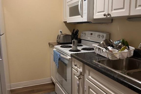Compact kitchen with white cabinets, oven, microwave, sink, and toaster. - 110, 14921 Macdonald Drive, Fort Mcmurray