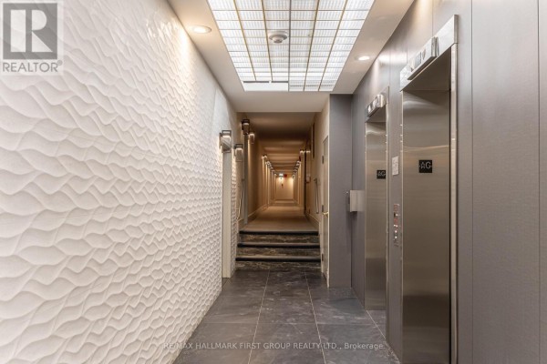 Elevator hallway with stainless steel doors, textured walls, and tiled floor. - 110 - 25 Cumberland Lane, Ajax