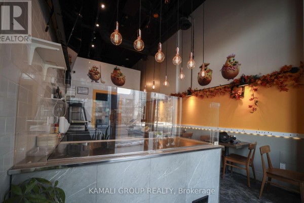 Bright dining area with yellow wall and wooden furniture - 110 - 28 Finch Avenue W, Toronto
