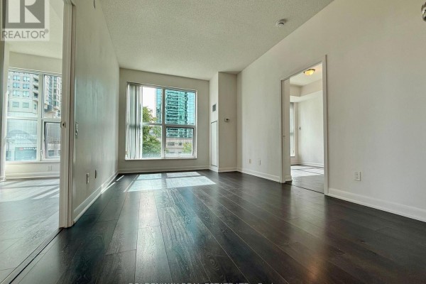 Bright living space with dark wood floors and views of city buildings. - 110 - 5168 Yonge Street, Toronto