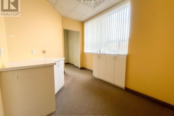 Small office area with yellow walls, counter space, and window blinds - 110-112 Third Street W, Cochrane