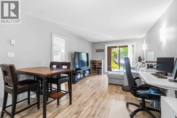 Kitchen featuring wood cabinets, granite island, stainless steel refrigerator, and oven. - 110 5889 Irmin Street, Burnaby