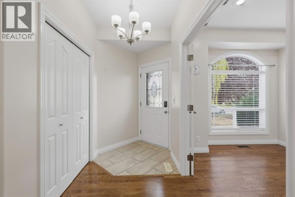 Entryway with beige walls, a white closet, and a glass-paned front door. - 110 Ainsworth Crescent, Red Deer